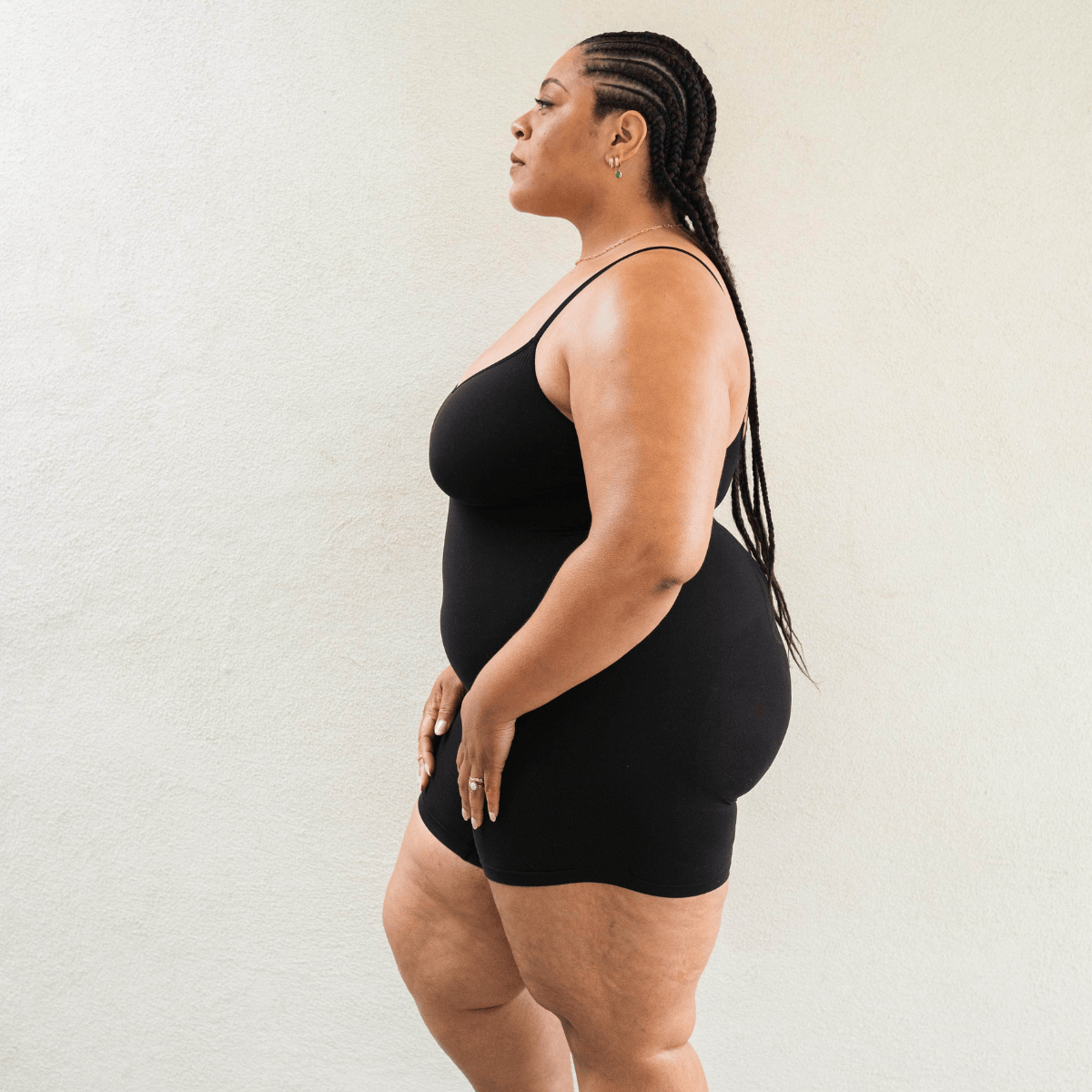 Side view of black seamless shapewear bodysuit showing flexible stretch and smoothing compression