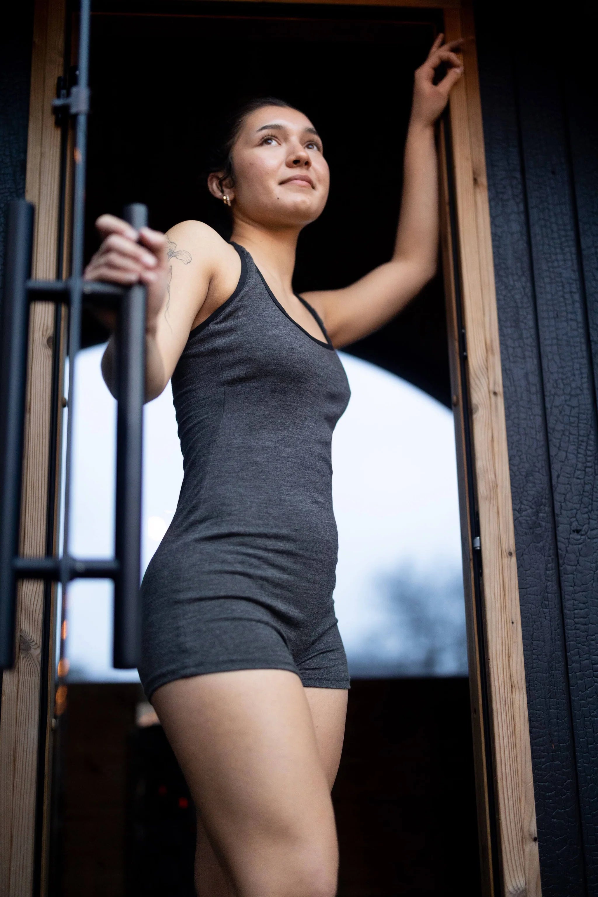 Woman wearing a merino wool sauna bath suit designed for sauna bathing, cold plunge transitions, and recovery routines.