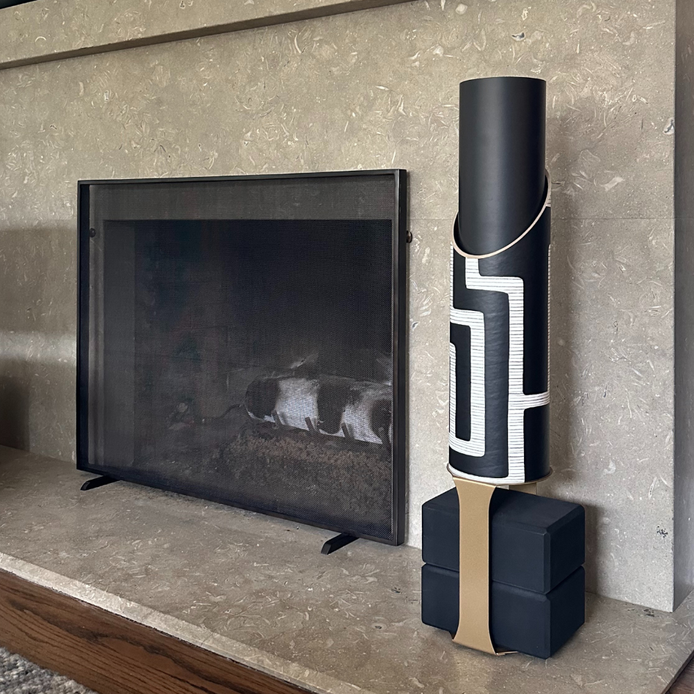 Colony yoga mat tube and black block base displayed beside a modern fireplace.