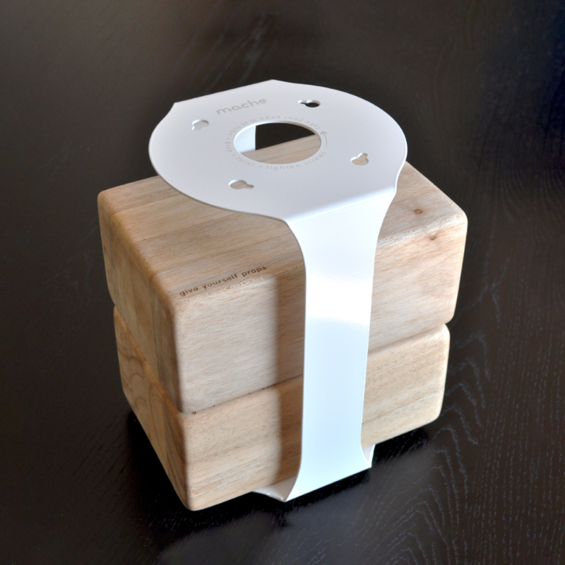 White metal support strap wrapped around the pale wood block base, viewed from above.