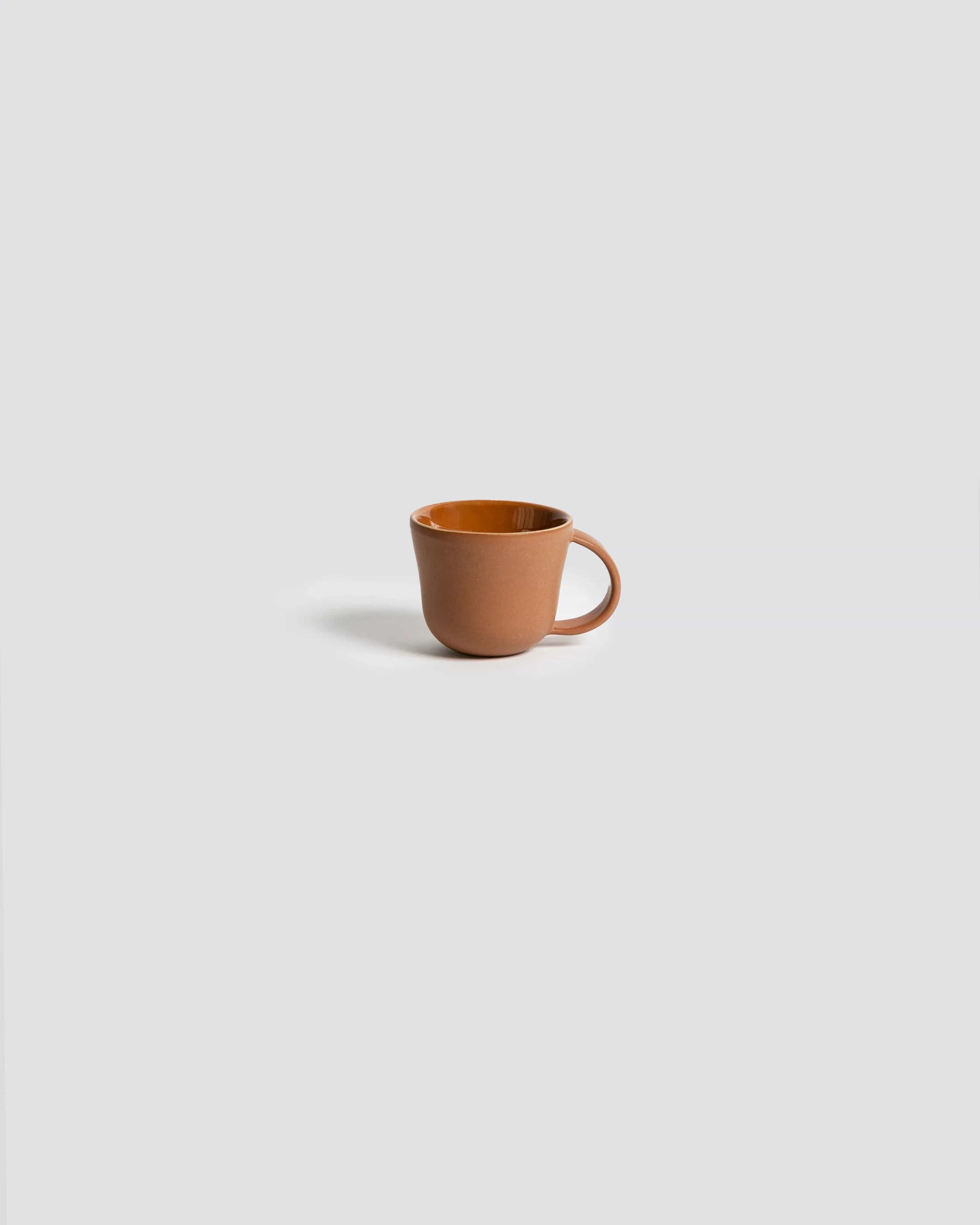 Stoneware mug in Terracotta side profile view on neutral background