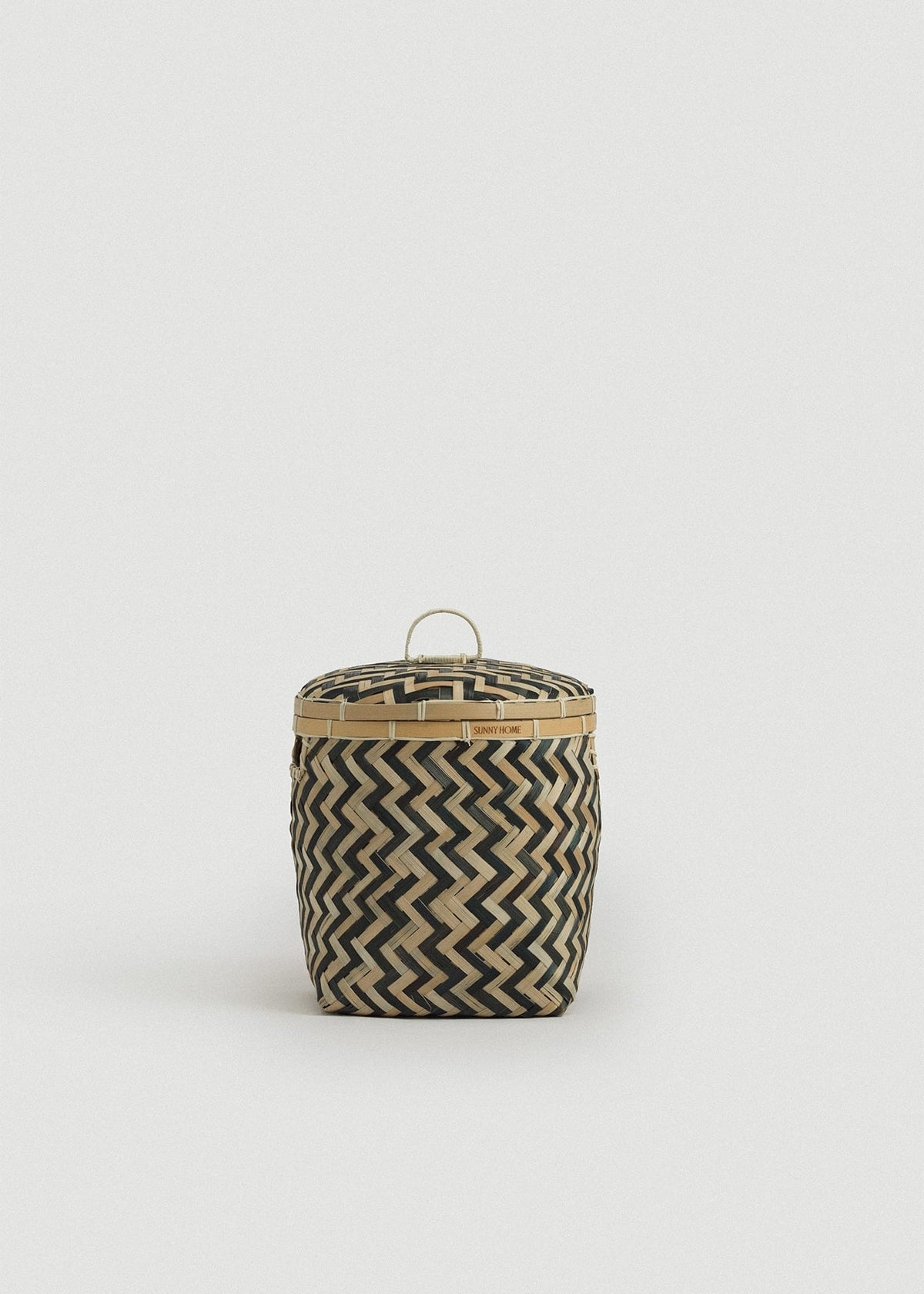 Small bamboo storage basket with a fitted lid, loop handle, and black-and-natural zigzag weave.