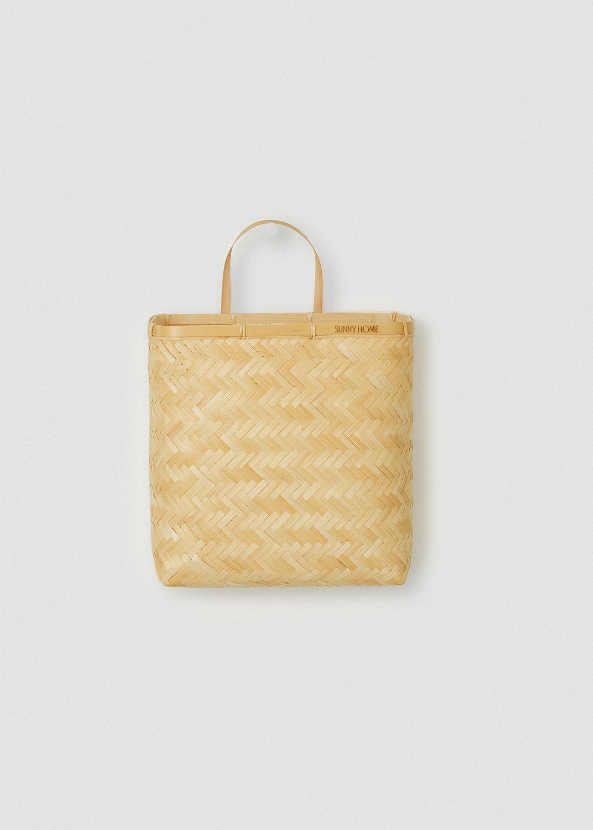 Flat rectangular bamboo wall basket with a natural herringbone weave and single loop handle.