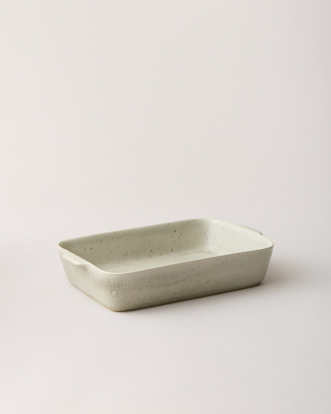 Empty warm stone Fieldstone Baker with a softly mottled beige-gray glaze, shallow interior, and gently flared rim.