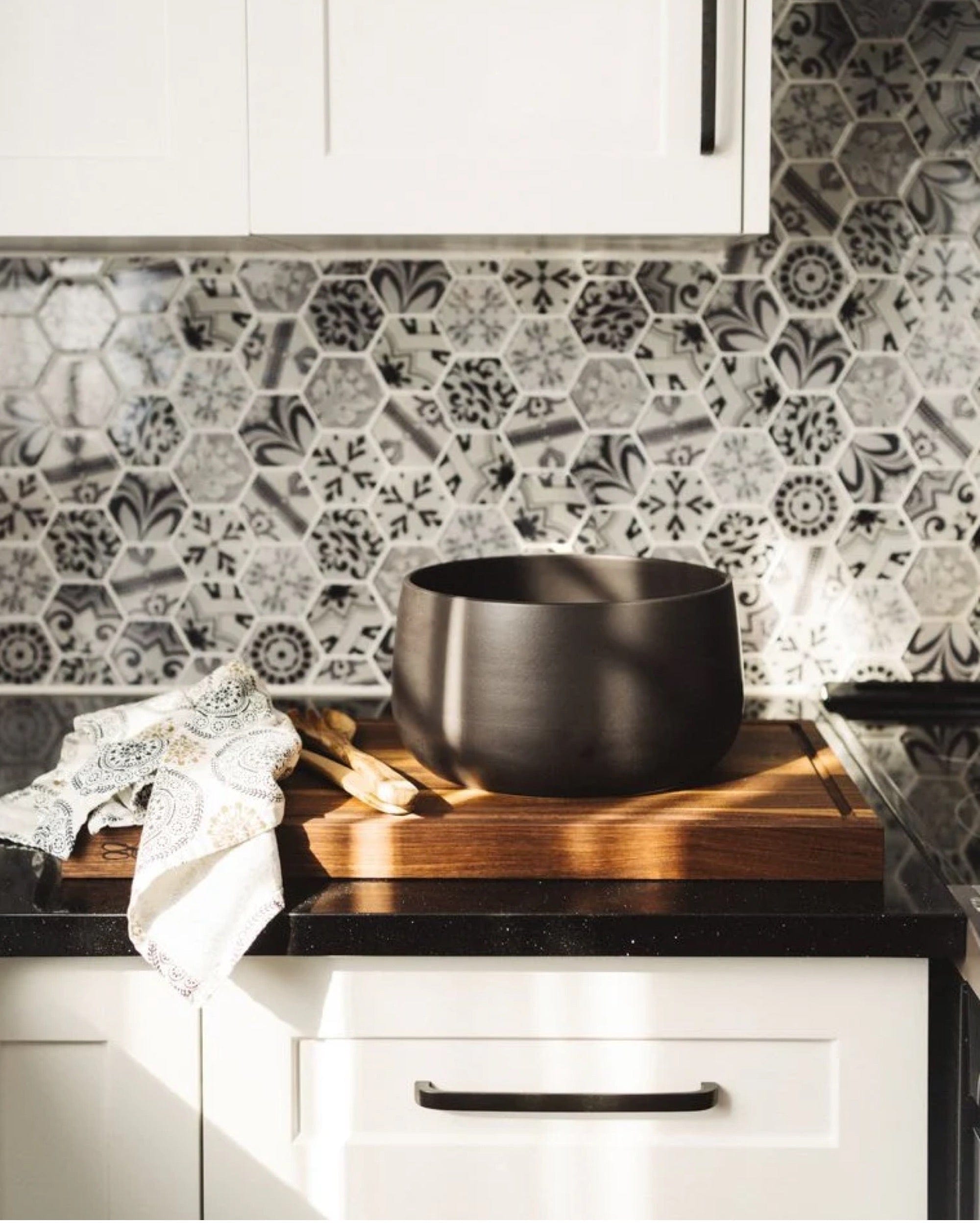 Stoneware serving bowl 120 oz in Matte Black styled on kitchen counter with cutting board