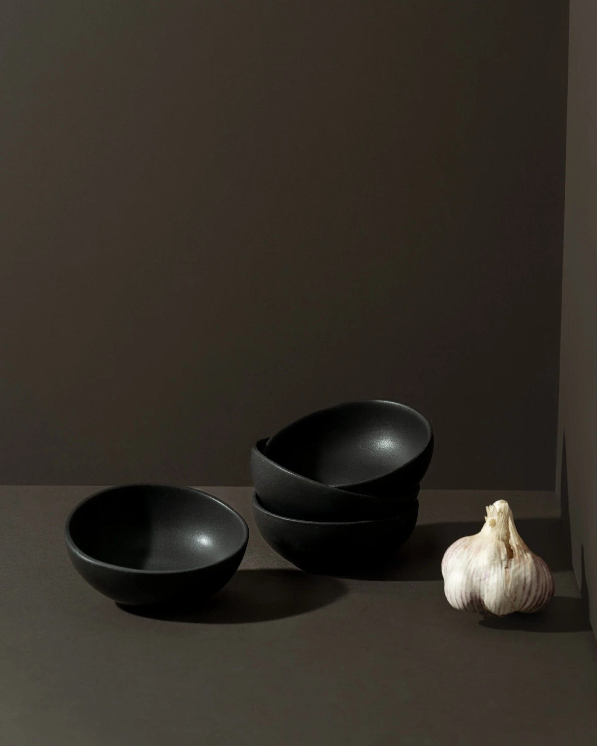 Stoneware bowls in Matte Black with garlic on dark background