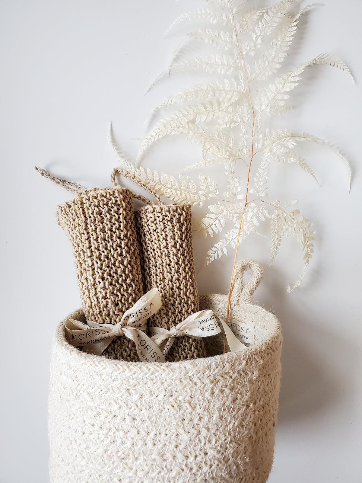Korissa Hemp Washcloth rolled in basket with pampas grass