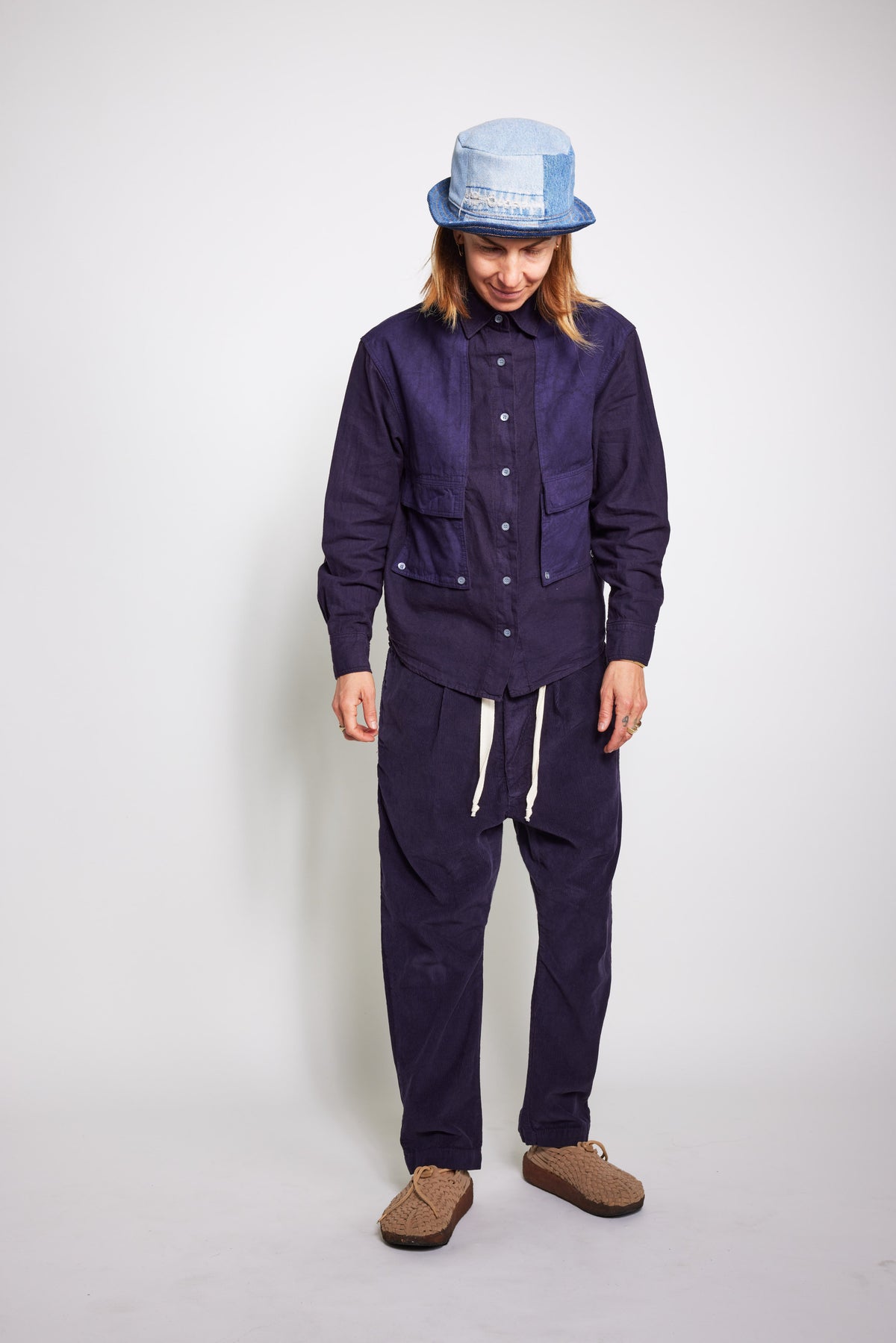 Front view of a model looking down in the navy Trek Shirt and matching pants.