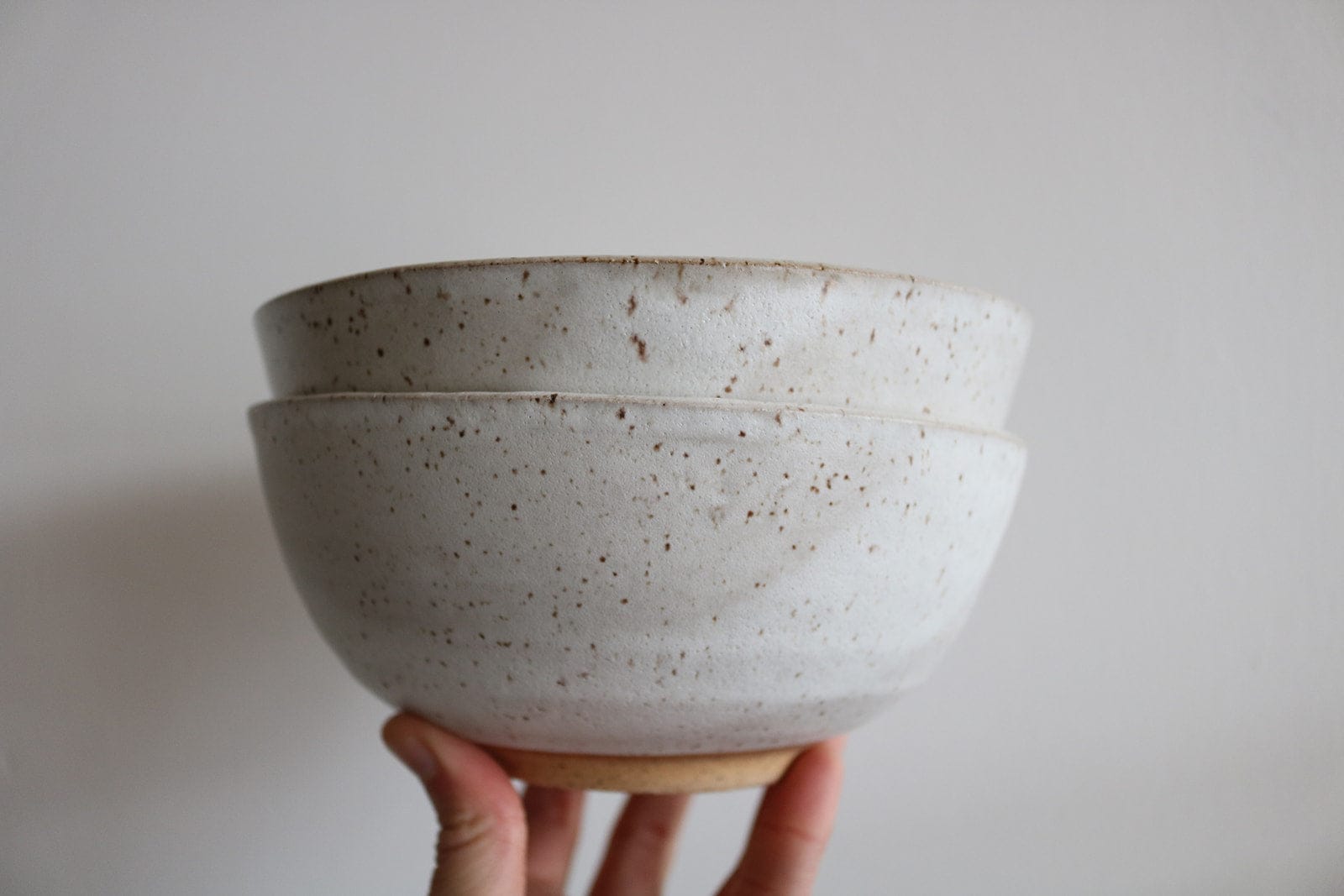 Stacked handmade ceramic cereal bowls in speckled white glaze by KJ Pottery