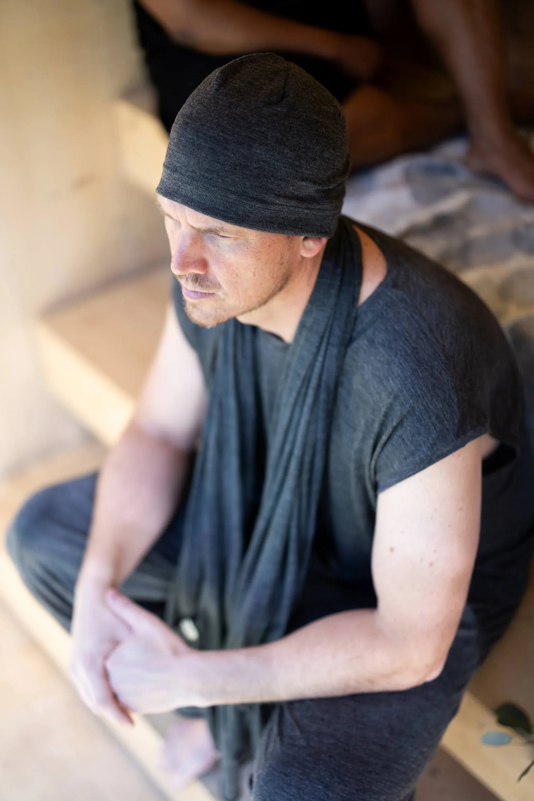 Merino wool sauna beanie worn during a sauna ritual, designed to support temperature regulation and everyday comfort.