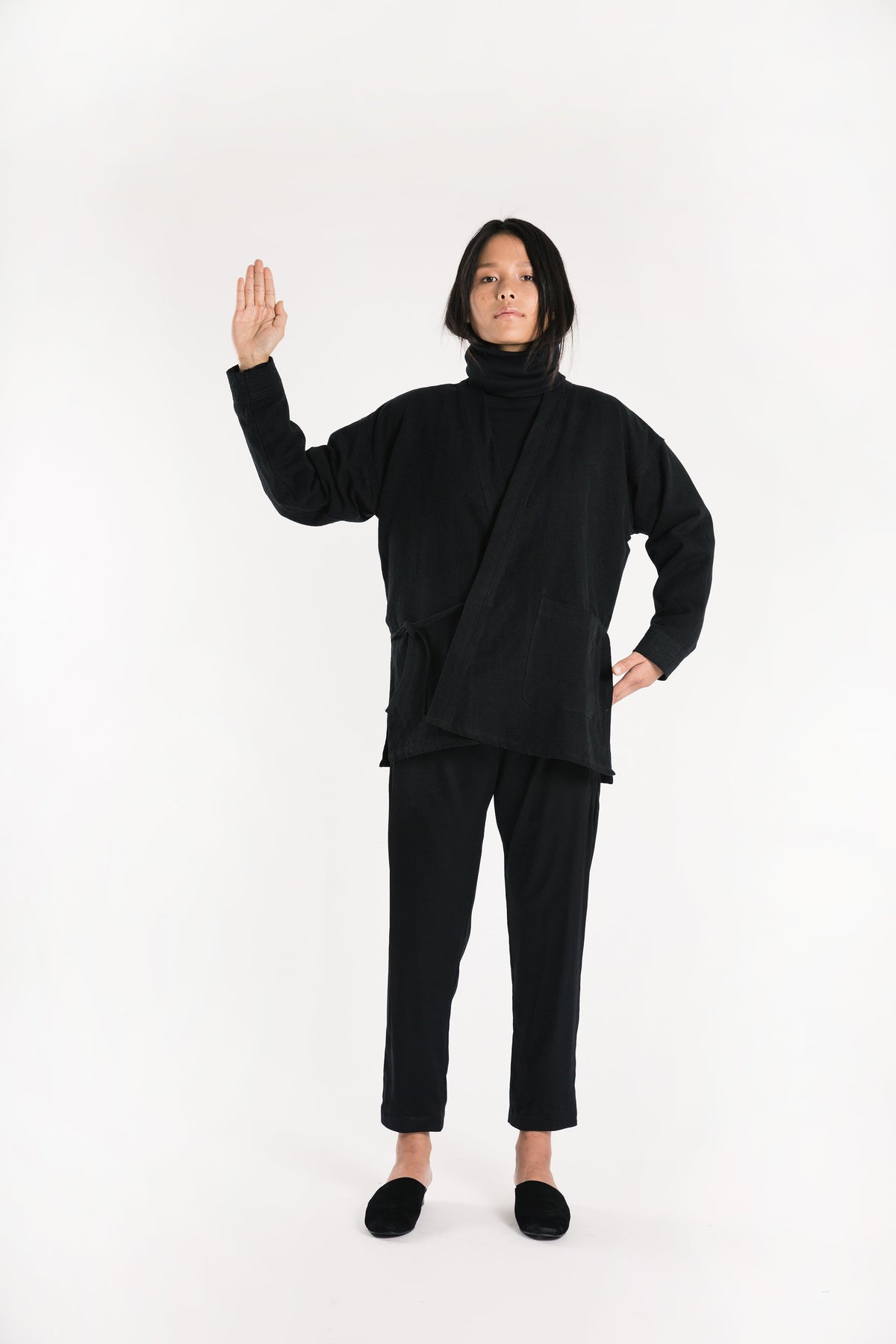 Model posing in black Souk pants with a matching black top.