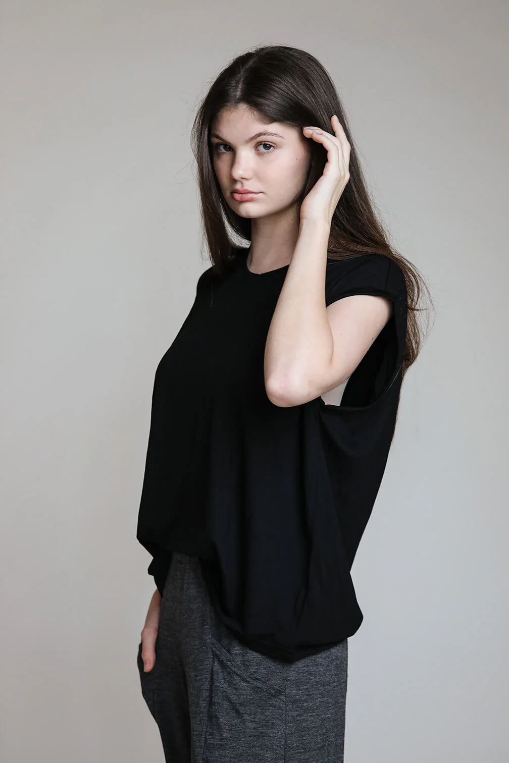 Woman wearing a black merino wool sauna tee with a relaxed silhouette for sauna bathing, recovery, and everyday wear.