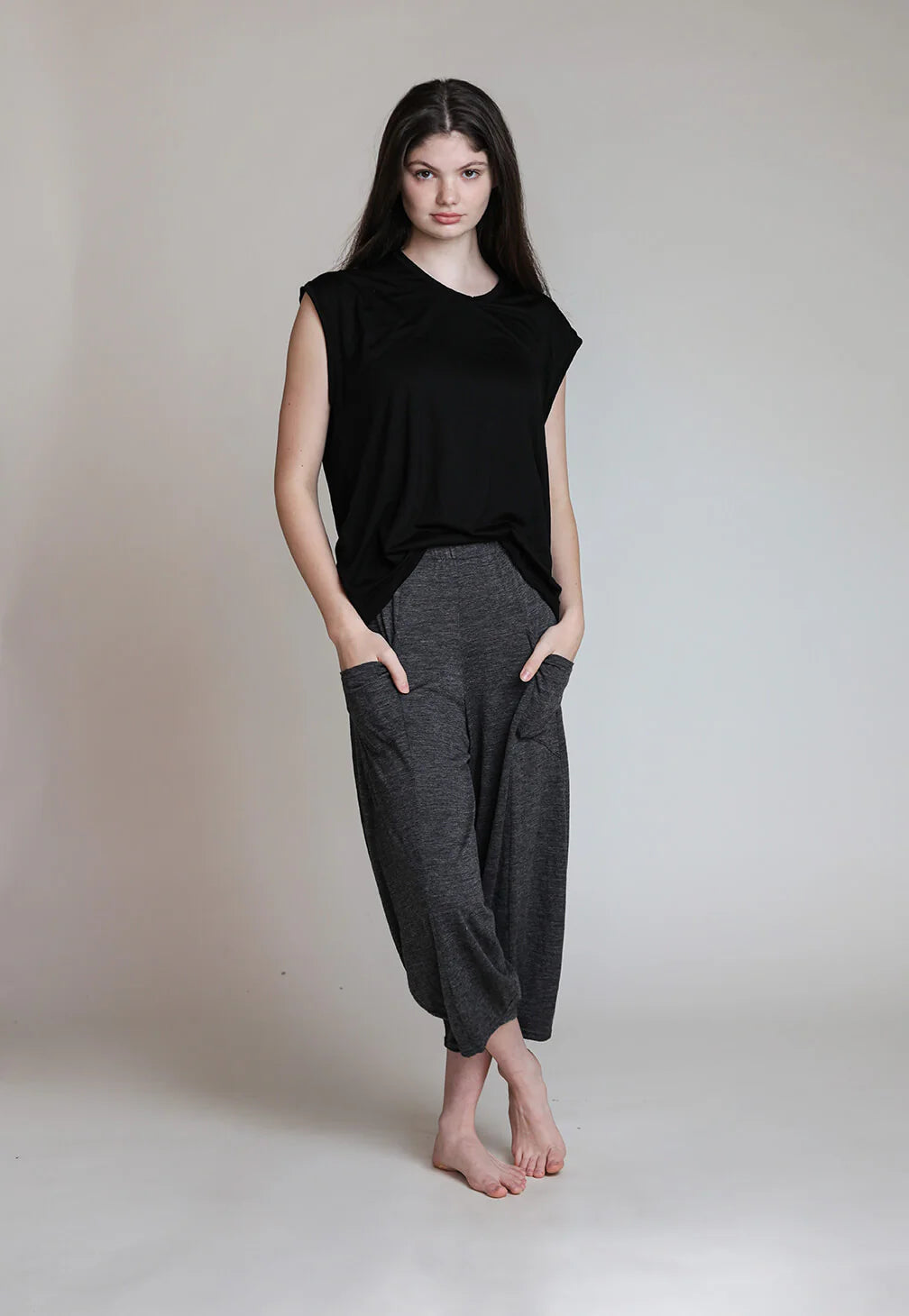 Woman wearing charcoal merino wool lounge pants designed for lounging, travel, and post-sauna recovery.