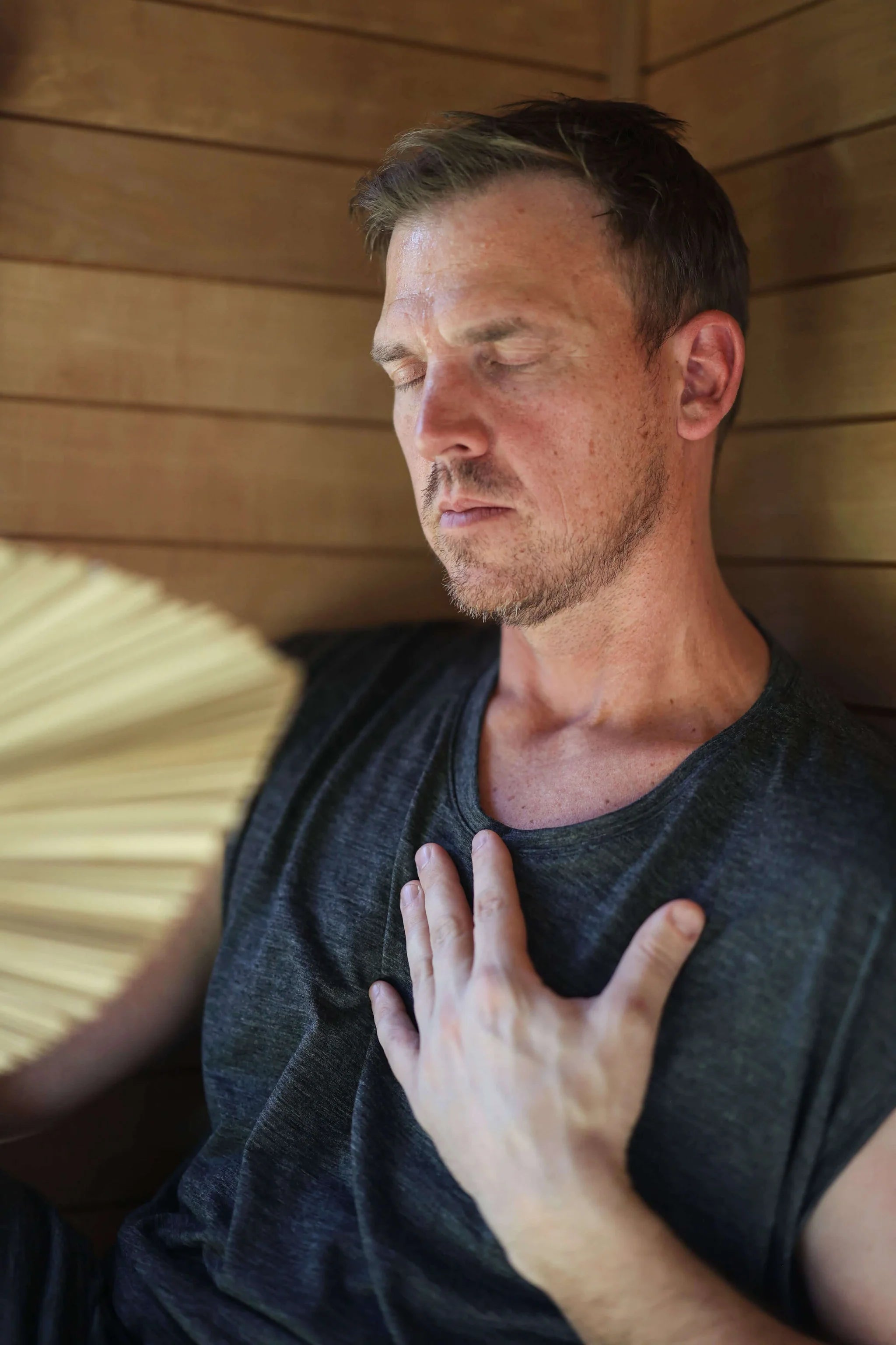Man wearing a merino wool sauna tee during a wellness and recovery ritual, emphasizing comfort and freedom of movement.