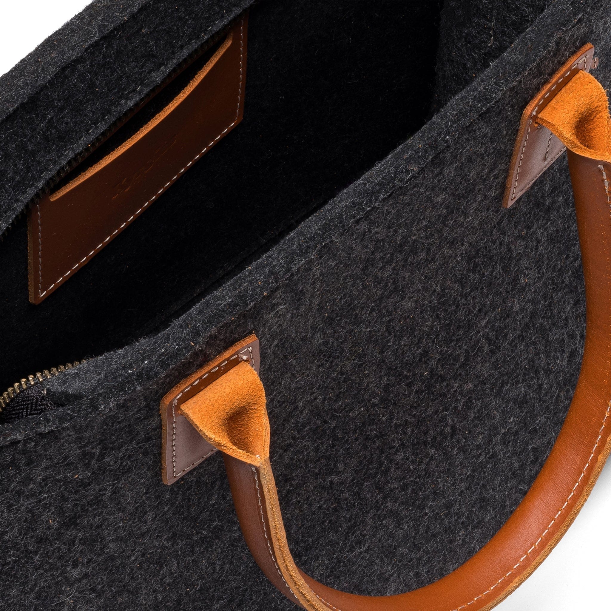 Interior detail of Kyrgies wool handbag showing natural wool felt construction and organizational pocket