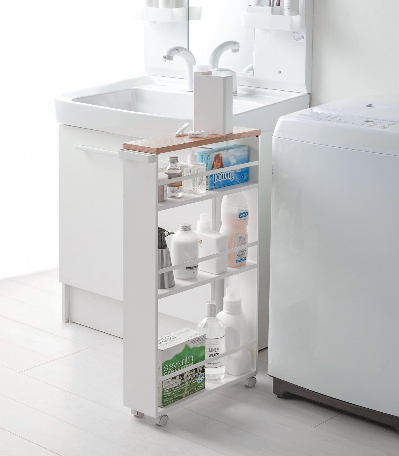 White rolling cart with shelves in a bathroom setting. Slim Storage Cart (32" H) - Steel shown in laundry room