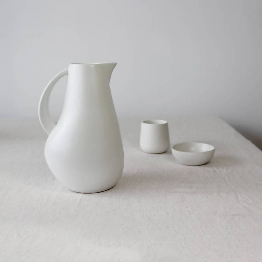 Stoneware pitcher 64 oz in Matte White styled with mug and bowl on linen tablecloth