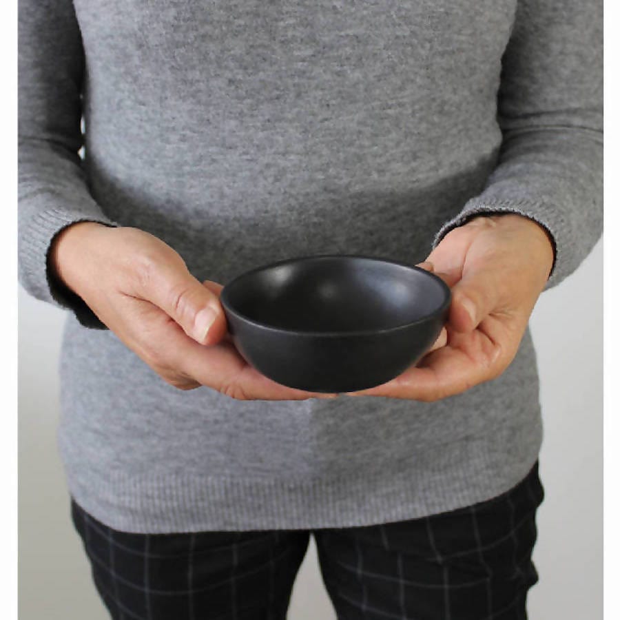 Person holding stoneware bowl in Matte Black to show scale