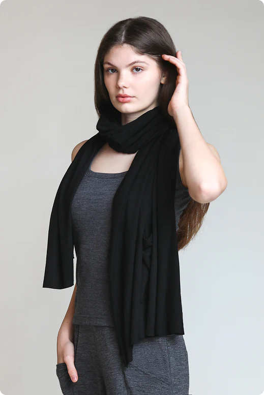 Woman wearing a merino wool pocket wrap as a scarf and shawl, showcasing versatile styling and natural comfort.