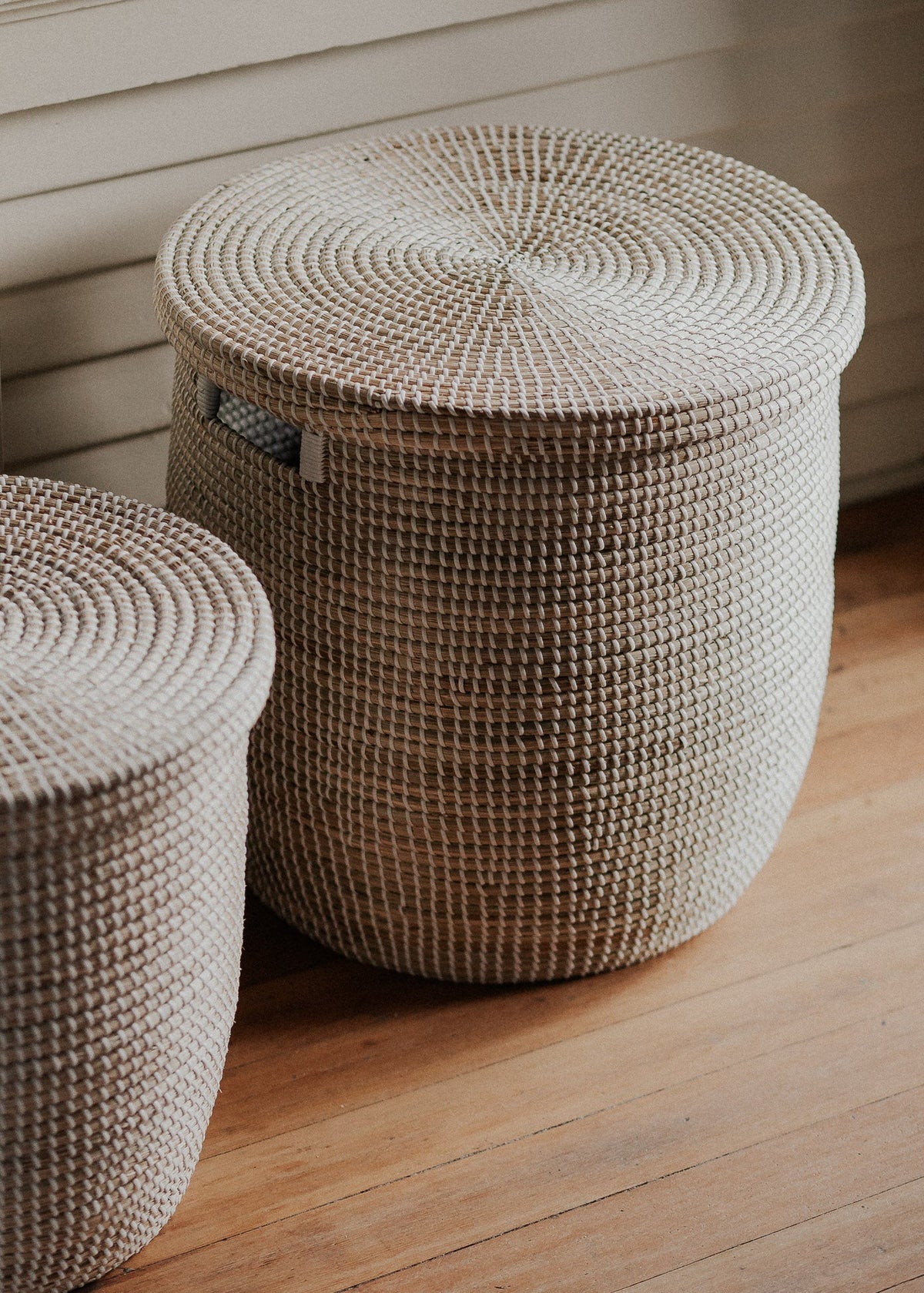 Close view of Medina baskets in a sunlit room, highlighting the natural woven fibers and spiral lid pattern.
