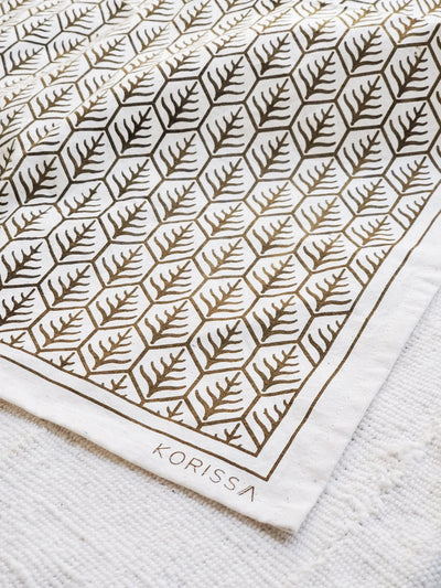 Korissa Hand Screen Printed Tea Towel, dark brown print, on woven natural-fiber mat