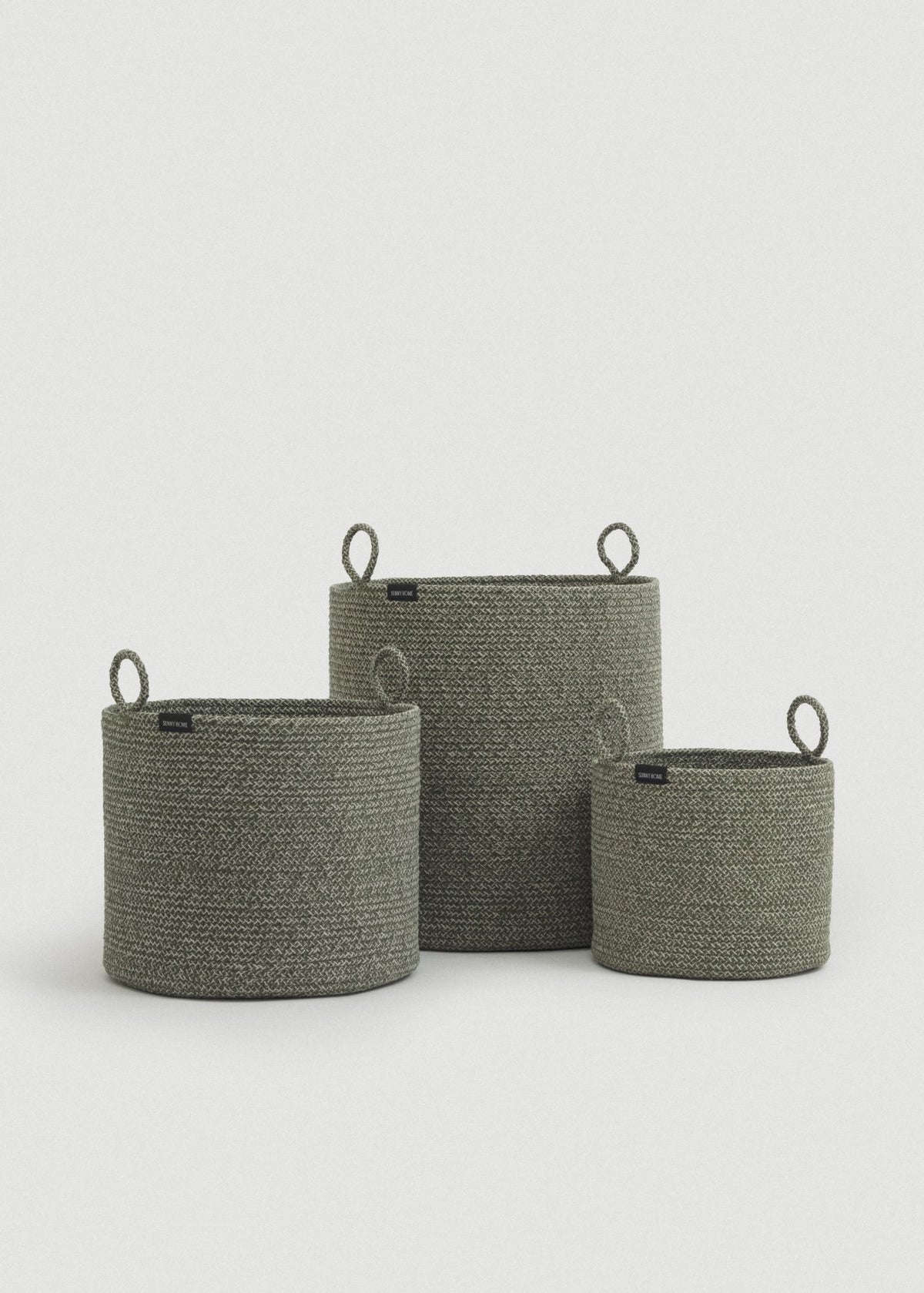 Three cotton rope baskets in graduated sizes arranged together.