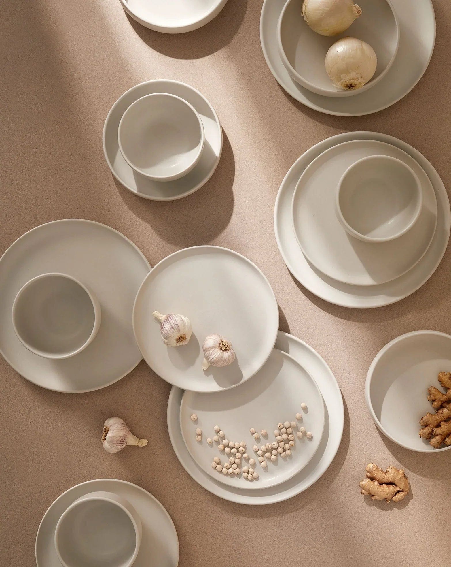 Gharyan Stoneware Japandi Tableware 12pc Dinnerware Set, Matte White, overhead with garlic, seasoning