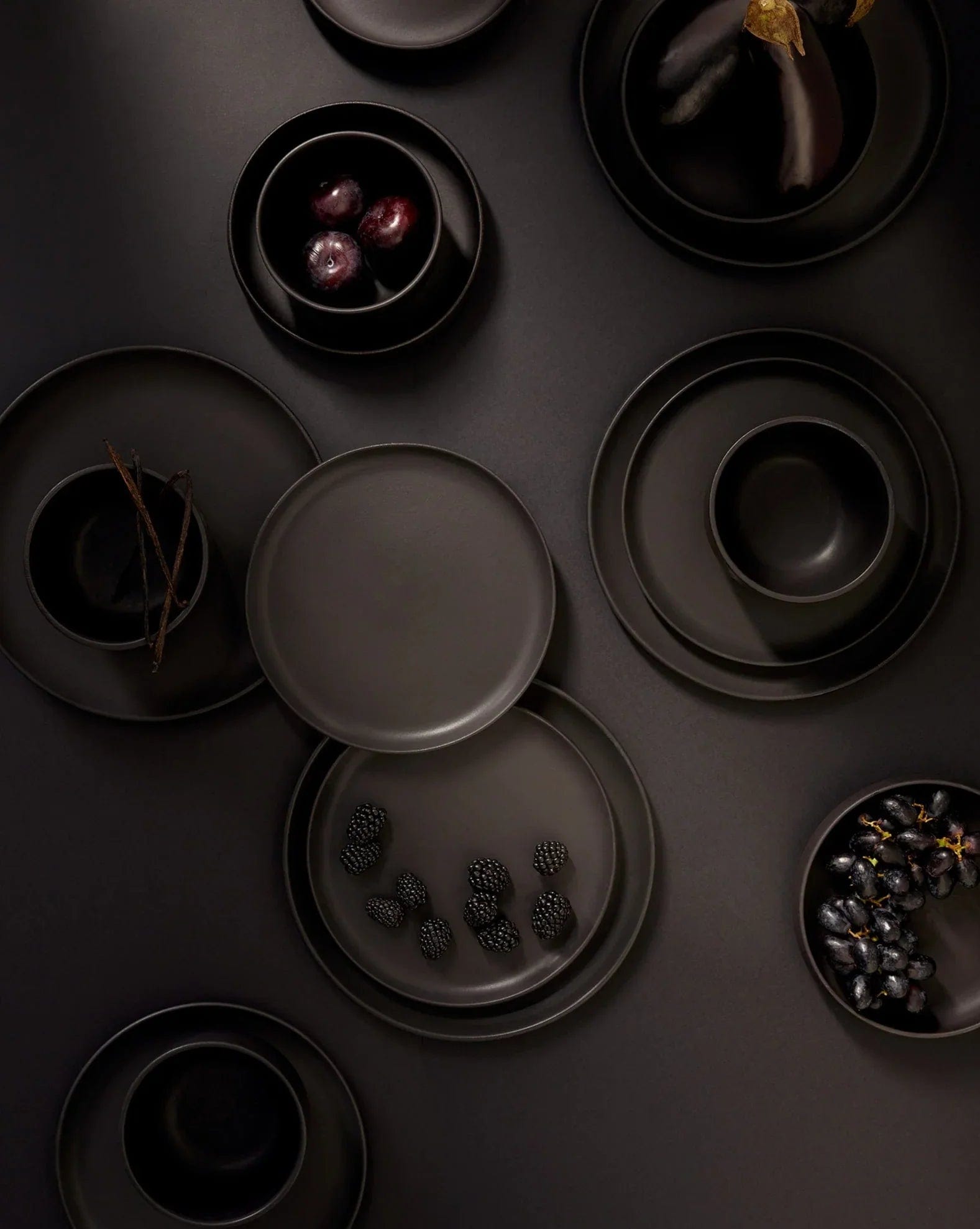 Stoneware dinner plates in Matte Black overhead view styled with bowls and ingredients