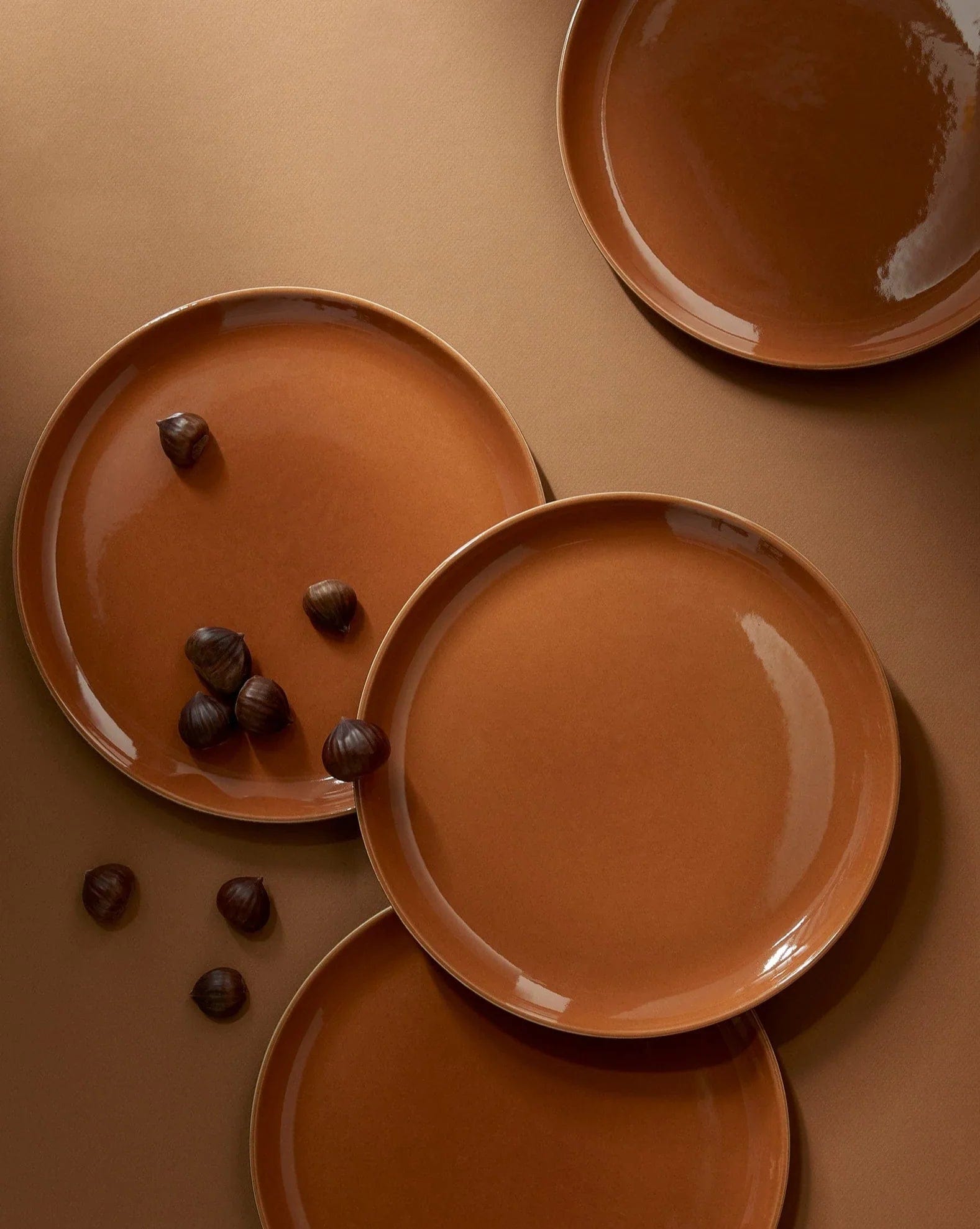 Stoneware dinner plates in Terracotta overhead view with chestnuts