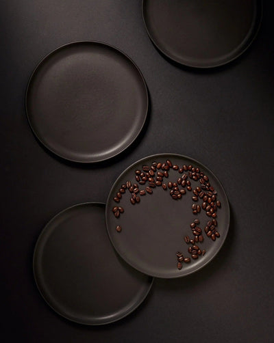 Stoneware dinner plates in Matte Black overhead view with peppercorns