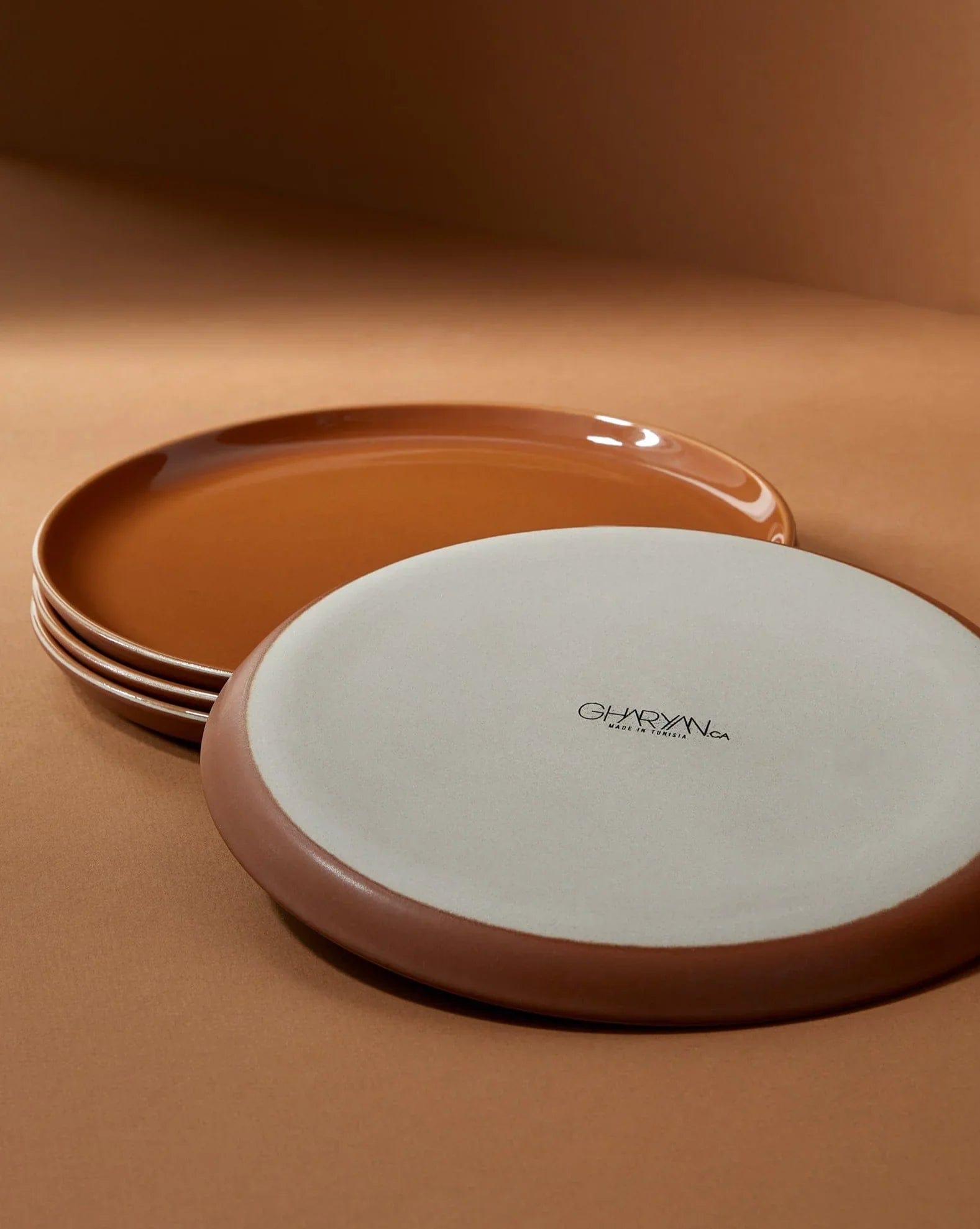 Stoneware side plates in Terracotta stacked showing glazed interior