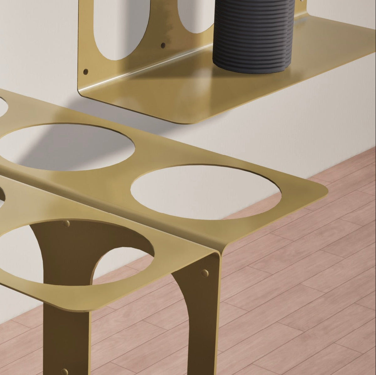 Close-up of the gold stand’s two-tier construction, rounded corners, circular openings, and curved vertical supports.
