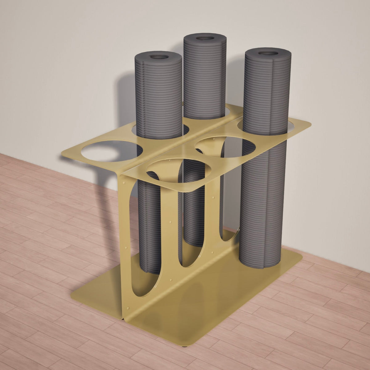 Gold six-slot floor stand holding four rolled gray mats or foam rollers on a light wood floor.