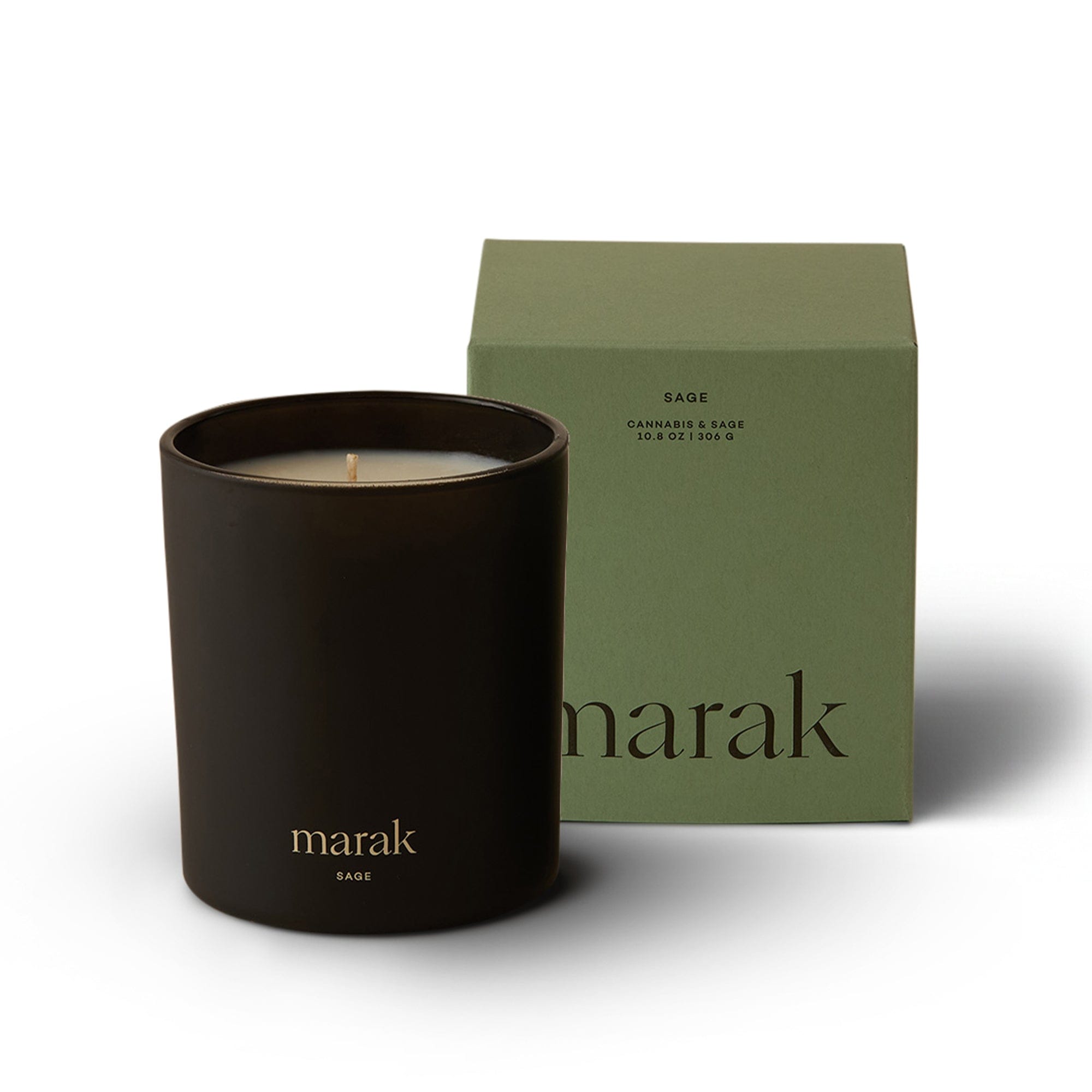 Black candle in a container with 'marak' branding next to a green box on a white background