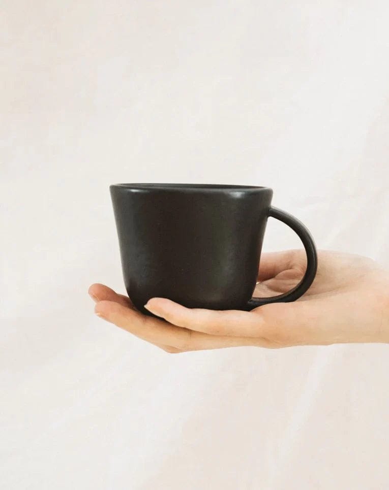 Person holding stoneware mug in Matte Black to show scale