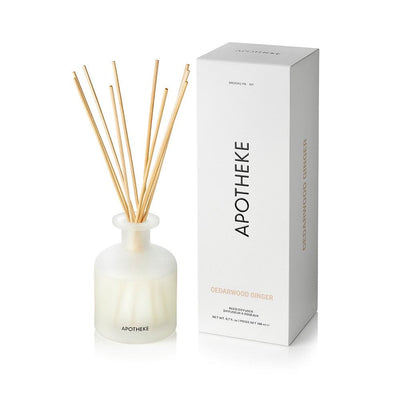 Cedarwood Ginger Reed Diffuser in frosted glass with natural rattan reeds beside APOTHEKE packaging box