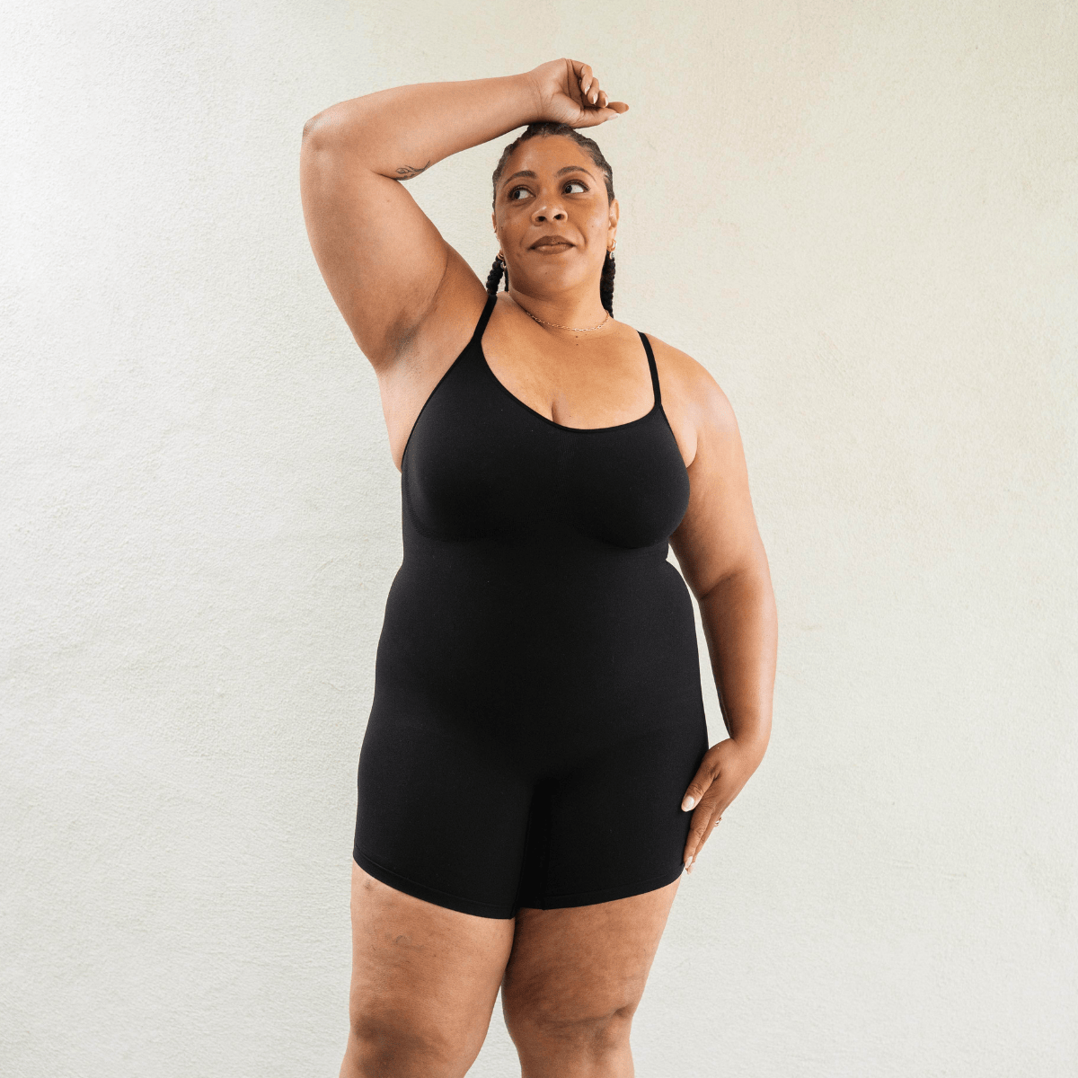 Model wearing black shapewear bodysuit with smoothing fit and breathable stretch