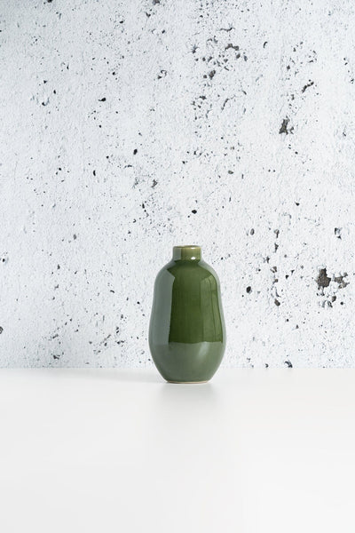 Stoneware vase in Matte Green against textured concrete background