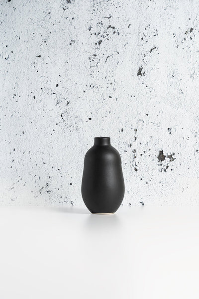 Stoneware vase in Matte Black against textured concrete background