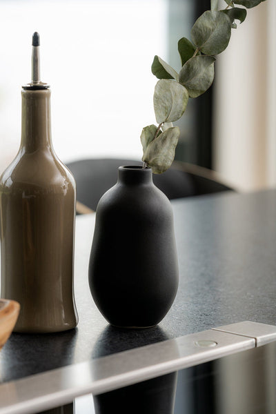 Stoneware vase in Matte Black on kitchen counter beside ceramic oil bottle
