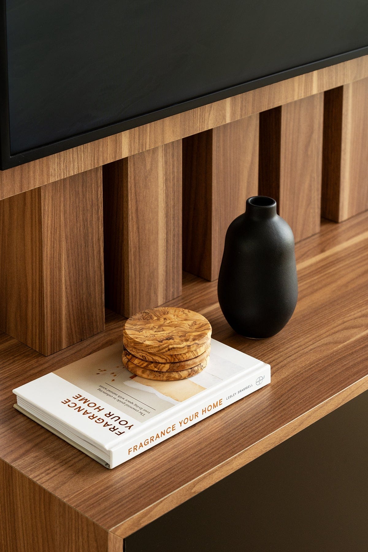Stoneware vase in Matte Black styled on wood shelf with stacked books