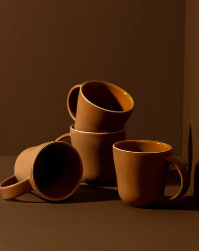 Stoneware mugs in Terracotta styled together on warm-toned background