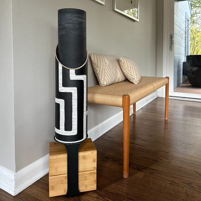 Full Colony tube and wooden block stand displayed beside a bench on a hardwood floor.