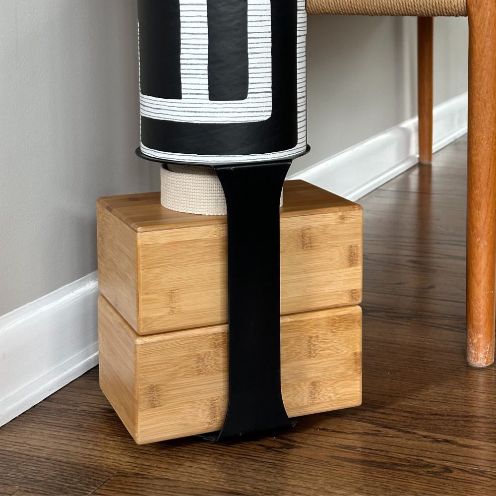Close-up of the Colony tube mounted above four natural wood blocks with a wide black support strap.