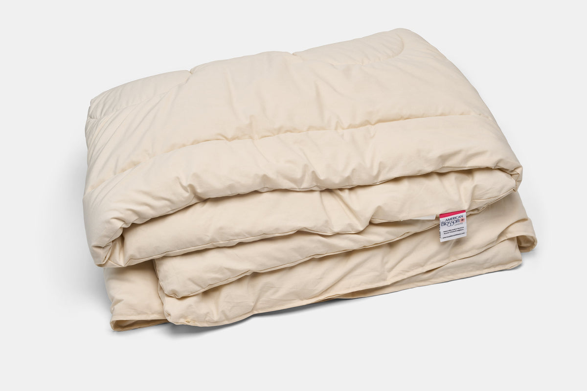 Folded American Blossom Linens natural wool duvet insert in an undyed cotton shell