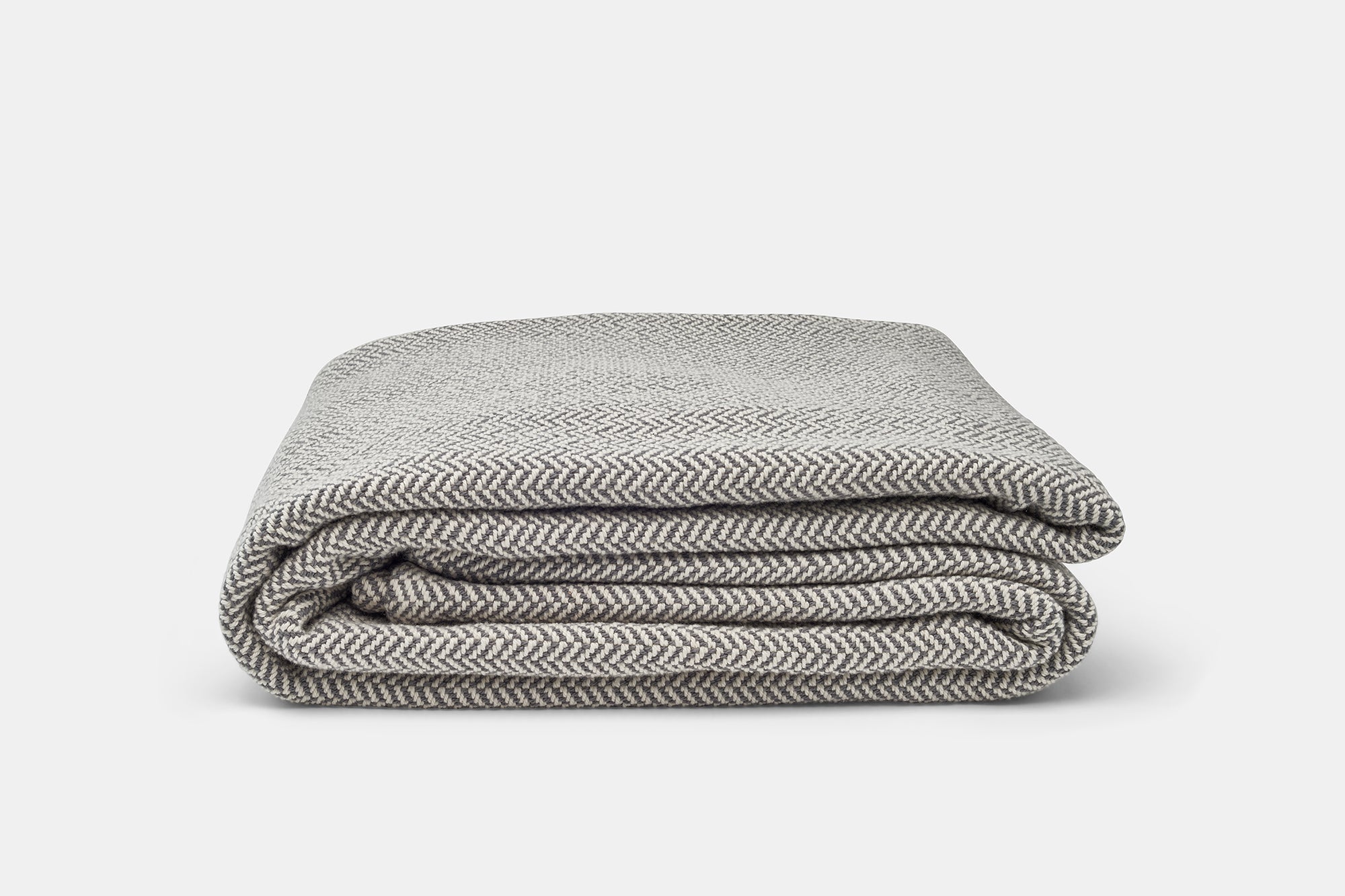 Folded gray and white striped blanket on a light gray background