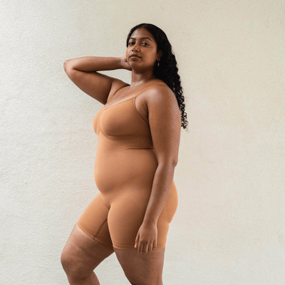 Side view of mid-thigh shapewear bodysuit showing smoothing support and comfortable stretch fit