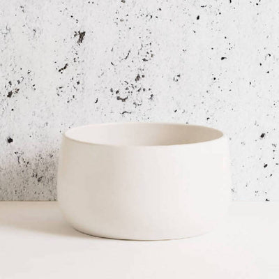 Stoneware serving bowl 120 oz in Matte White against textured concrete background