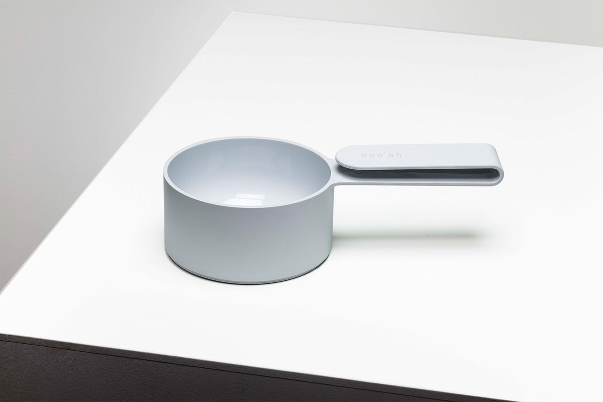 Pale blue-gray Mogo Scooper with a deep round measuring cup and short flat rectangular handle, displayed on a white tabletop.