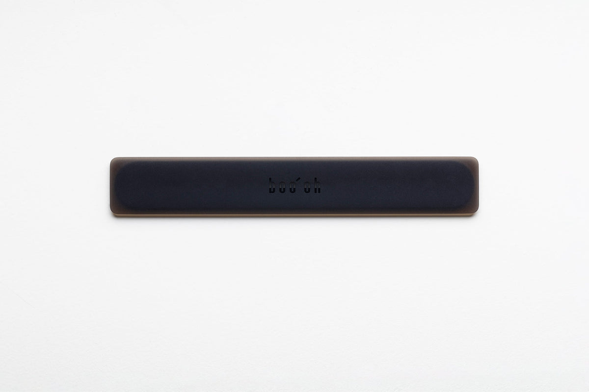 Slim matte-black Mogo Spatula laid horizontally, with a low-profile rounded rectangular shape and small Boo Oh logo centered on the handle.